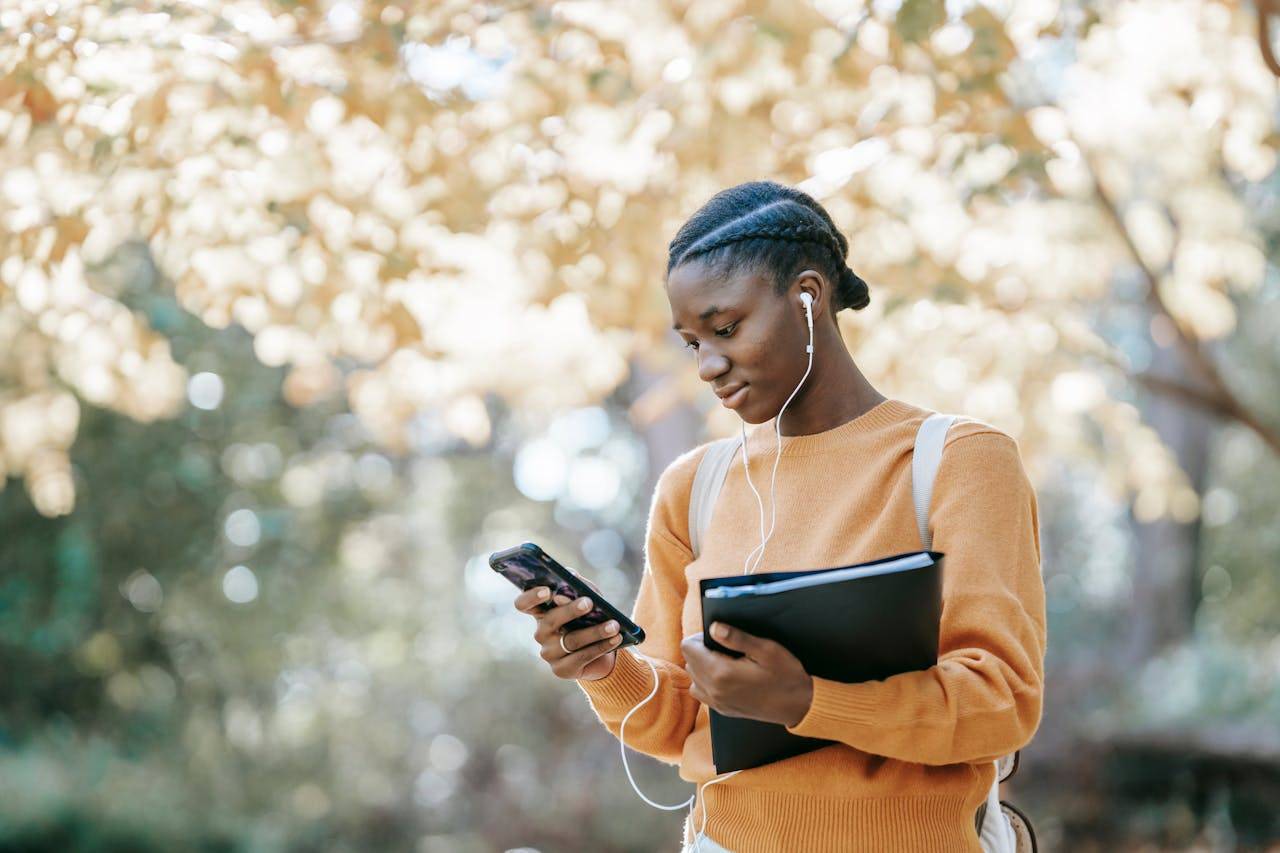 Person holding mobile phone and typing on screen, utilizing a chatbot for Instagram communication.